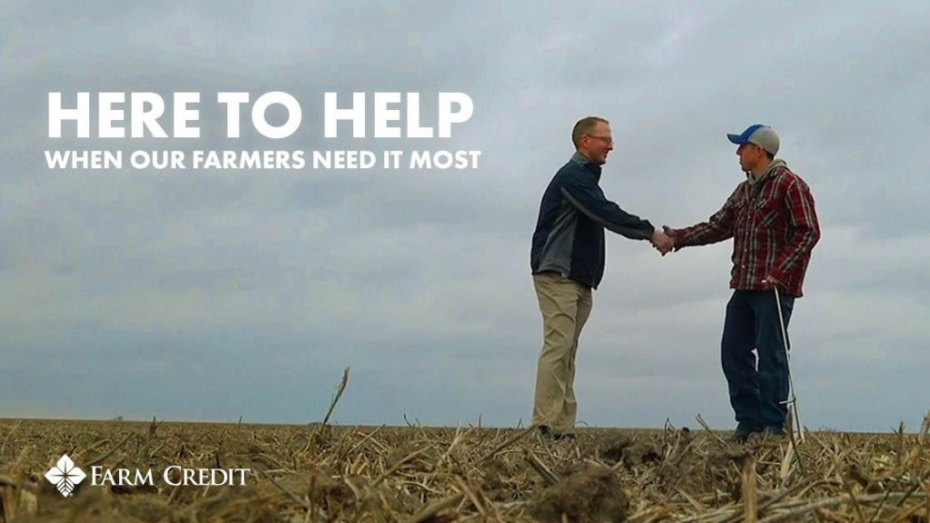 two men shaking hands in a field with the text Here to Help When Our Farmers Need It Most